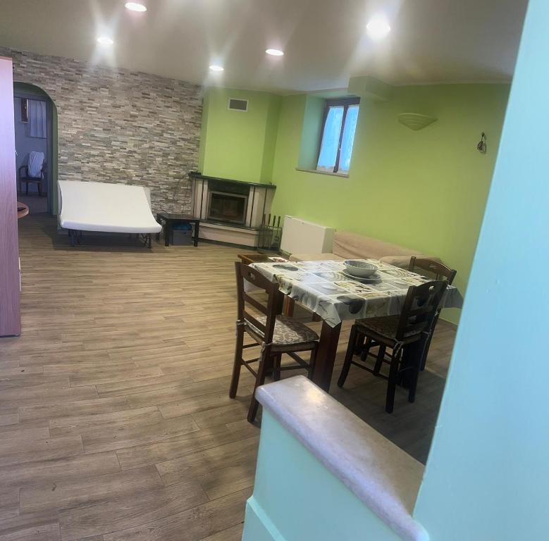sala de estar con mesa, sillas y sofá en PM 1 Via Valle Canestra Guest House, en Colonna