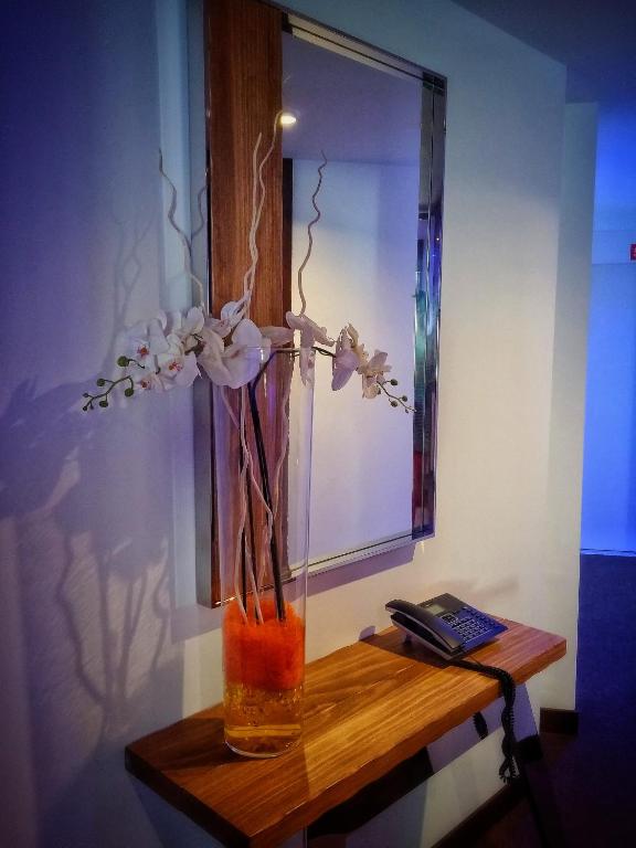 a vase with flowers in it on a table at MB Boutique Hotel - Adults Recommended in Nerja