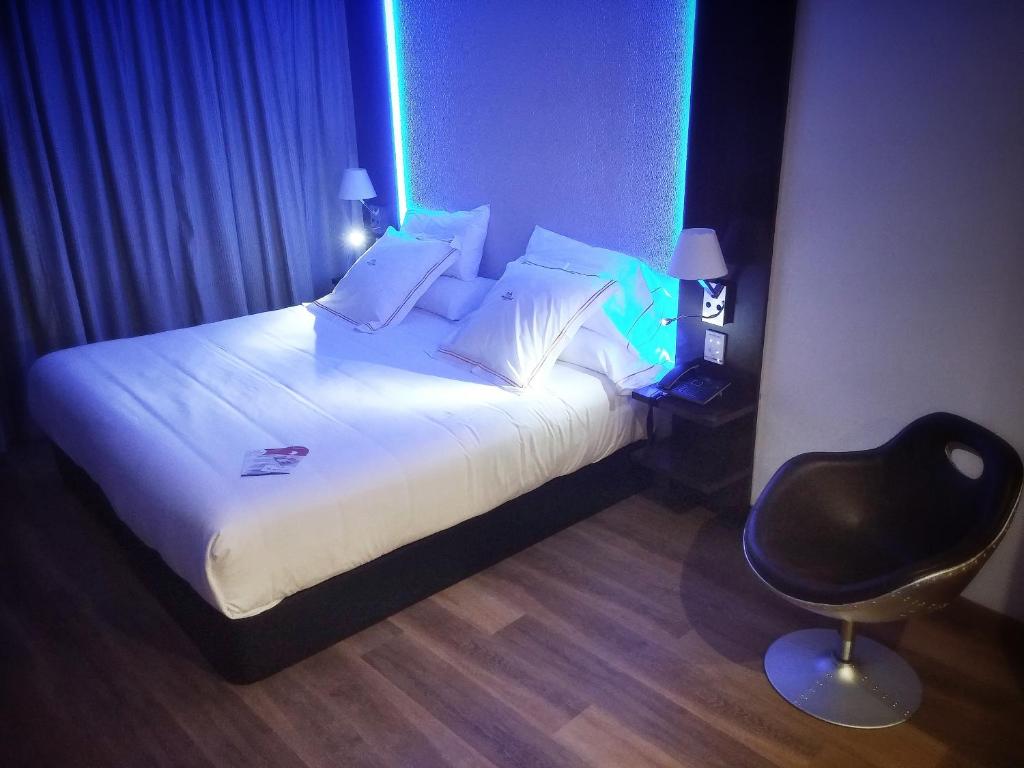 a bedroom with a bed and a chair in a room at MB Boutique Hotel - Adults Recommended in Nerja