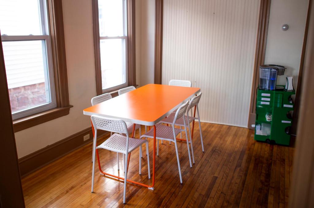 een tafel en stoelen in een kamer met houten vloeren bij My Cousins Place in Burlington