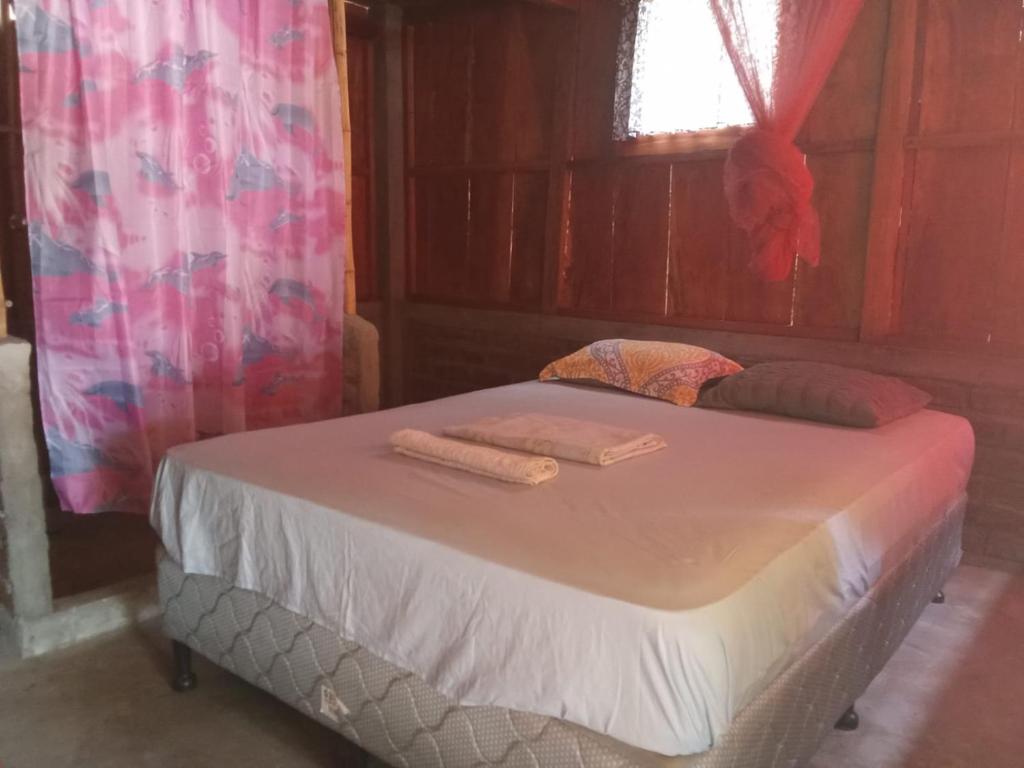 un letto in una stanza con due asciugamani di Casa de la playa la Malinche a Santa Cruz