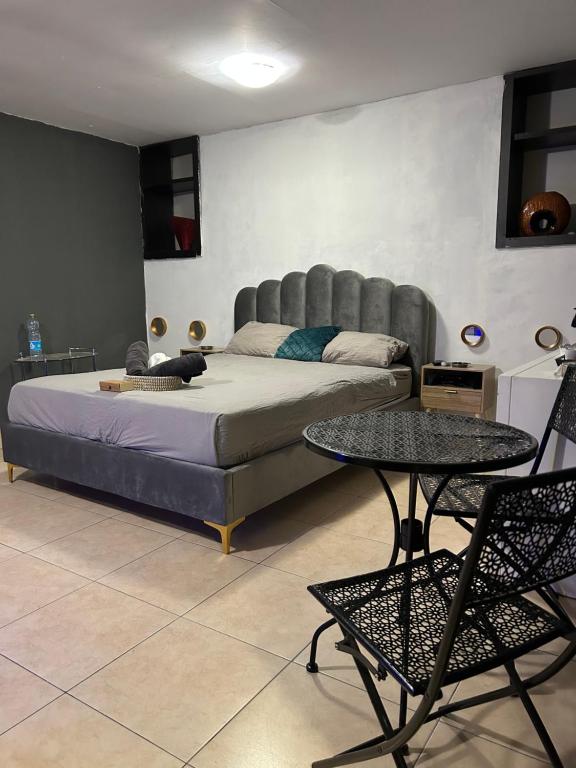 a bedroom with a bed and a table and chairs at Roof top glamping and Toys suites in Eilat