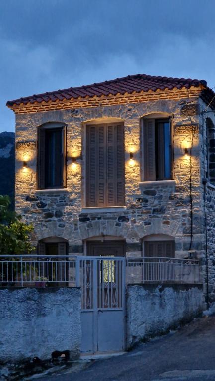 a stone house with lights on the front of it at Vagia's Home in Kymi