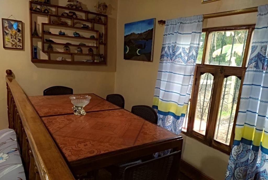 a dining room with a wooden table and a window at La casa de los Ciprés in San Cristobal