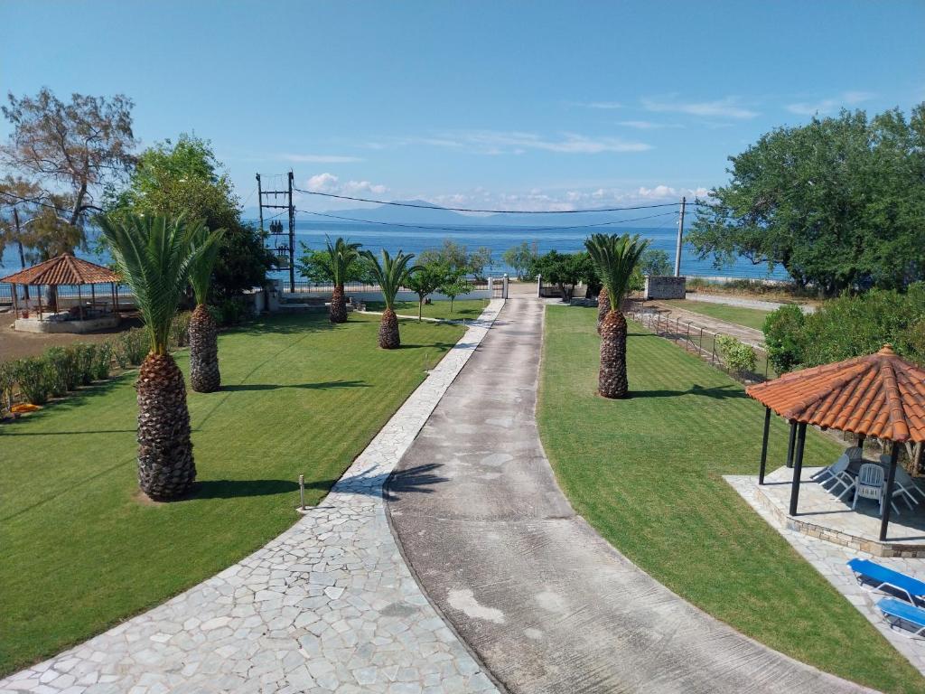 a walkway with palm trees in a park at Villa Kallimanis in Platanidia