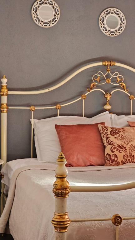 a bedroom with a gold and white bed with red pillows at Apartment Mint&Rose in Risan