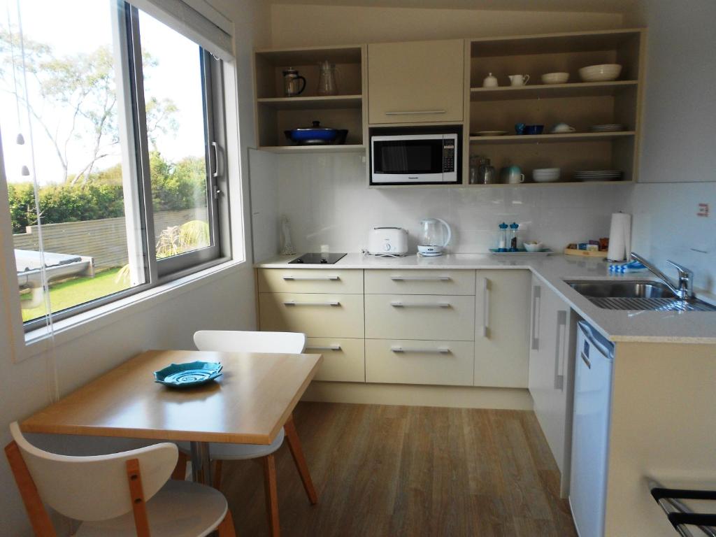 a small kitchen with a table and a sink at Oneroa Secret Garden Apartments in Oneroa