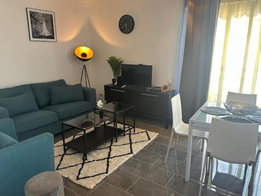 un salon avec un canapé bleu et une table dans l'établissement Lovely Stay in Roquebrune-Cap-Martin With See View, à Roquebrune-Cap-Martin