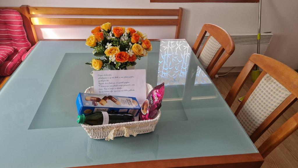 a glass table with a bouquet of flowers on it at Apartma Zala-Terme Čatež in Mostec
