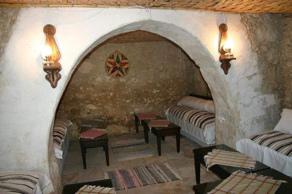 um quarto com várias camas numa parede de pedra em Eco Nitovikla 