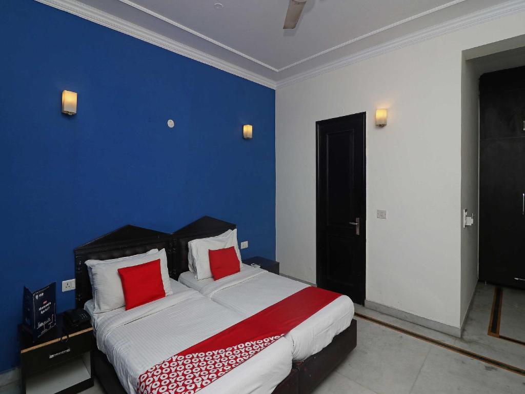 1 dormitorio con 1 cama grande con almohadas rojas en Golden Cafe en Chennai
