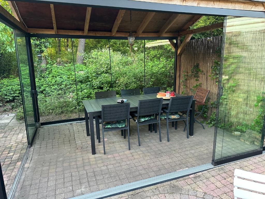 un patio con mesa y sillas en un pabellón en Vakantiepark de zanderij en Voorthuizen