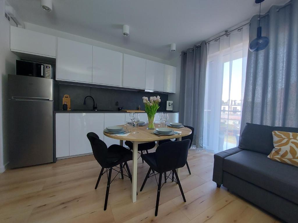 Una cocina y un comedor con mesa y sillas. en Apartament u Moniki, en Międzywodzie