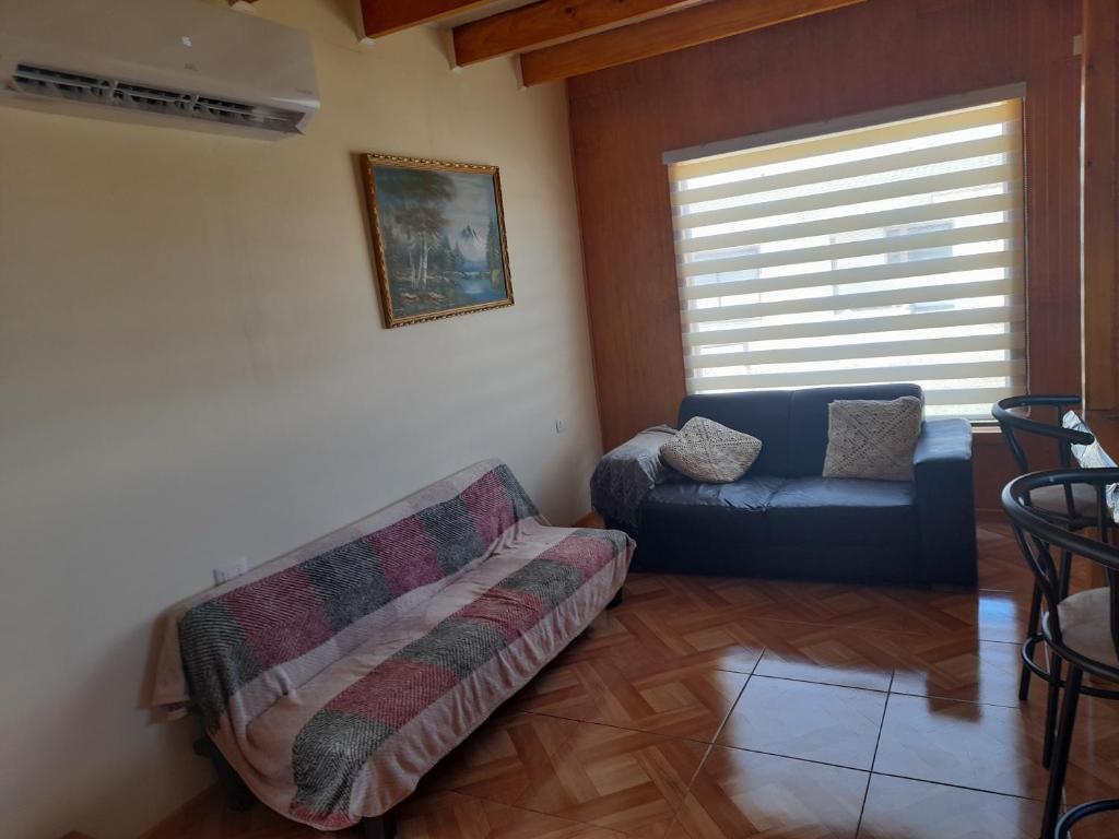 ein Wohnzimmer mit einem Sofa und einem Stuhl in der Unterkunft Cabañas Lya in Puyehue