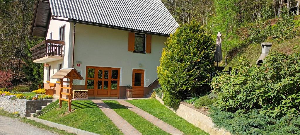 Holiday Home Forest Peace, Lavrovec في Hlevni Vrh: منزل أبيض صغير مع مسار يؤدي إليه