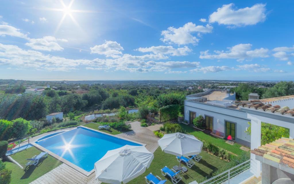 een luchtzicht op een huis met een zwembad en parasols bij Casas de Campo em Estoi by Garvetur in Estói