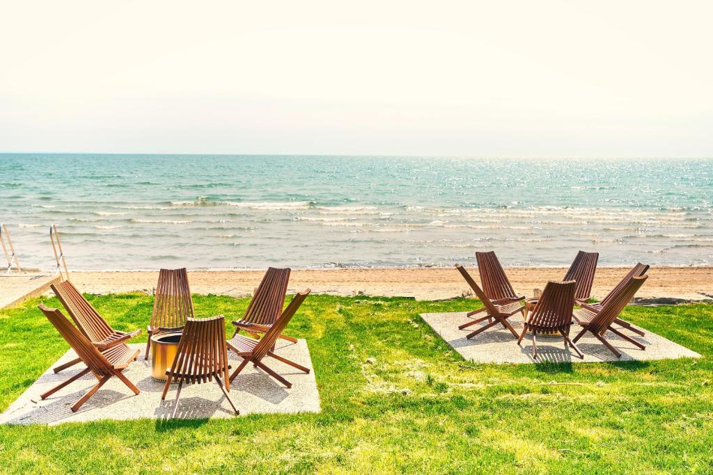 eine Gruppe Stühle und ein Tisch am Strand in der Unterkunft TheLongBeachResort - Beachfront Cottages & Townhouse Suites in Wainfleet