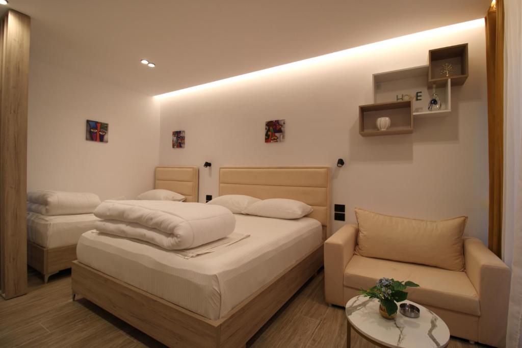 a bedroom with two beds and a couch at Reni Risi Deluxe Studio in Sarandë