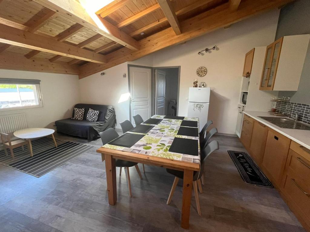 a kitchen and living room with a table and a kitchen and a couch at Vacances à la ferme en Ardèche 