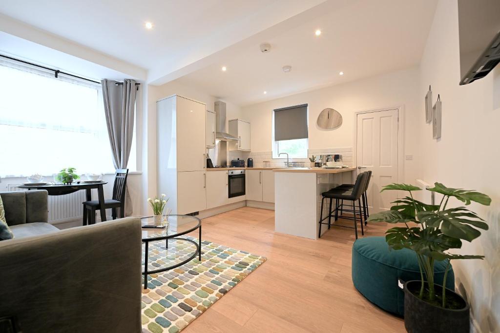 a living room and kitchen with a couch and a table at Bright & Large 3 Bed Flat in London in London