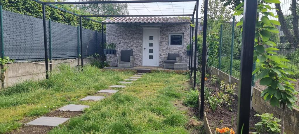 un jardín con pérgola y una casa en Studio Alex, en Gante