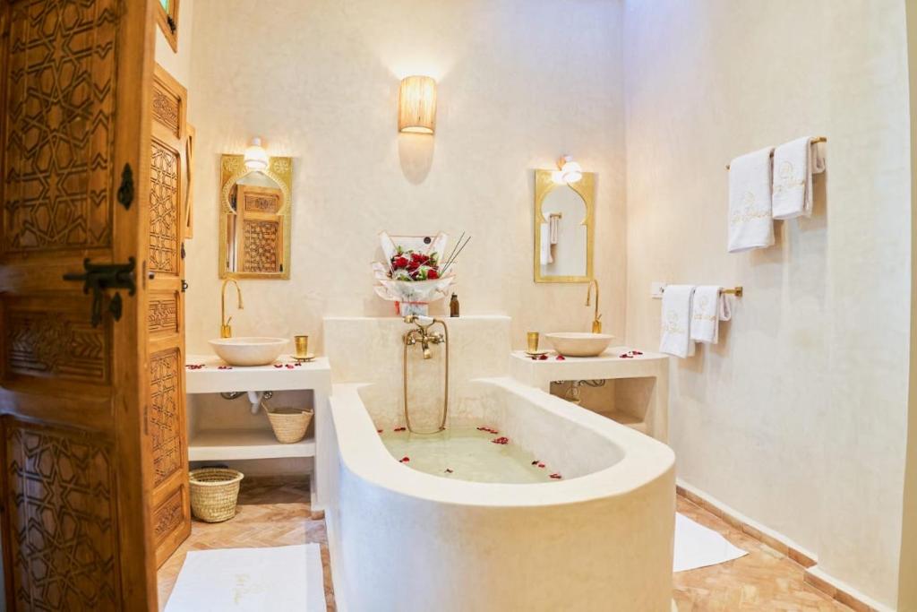 ein weißes Badezimmer mit zwei Waschbecken und einer Badewanne in der Unterkunft DAR SOHAN Kasbah vue mer in Tangier