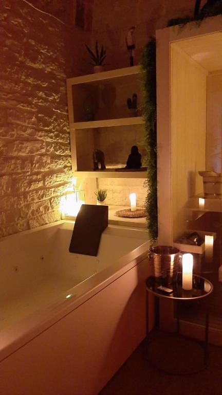 a bathroom with a bath tub with a table and candles at Alle volte Maison deluxe in Giovinazzo