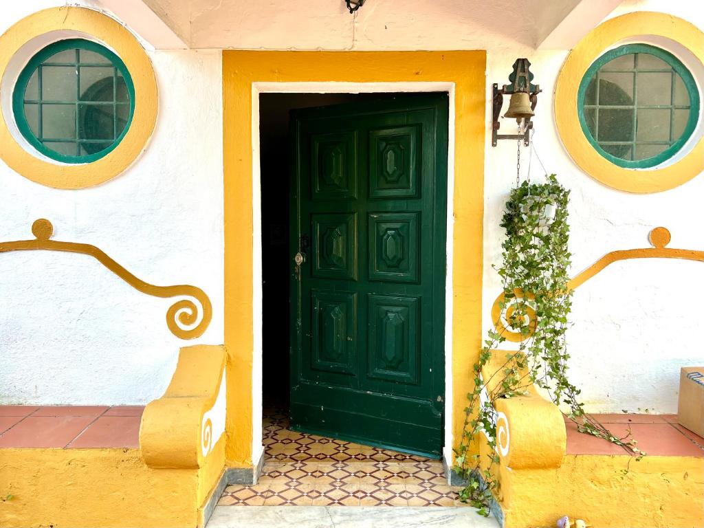uma porta verde numa casa com duas janelas em Qta Casa Seleiras - Guest House em Évora
