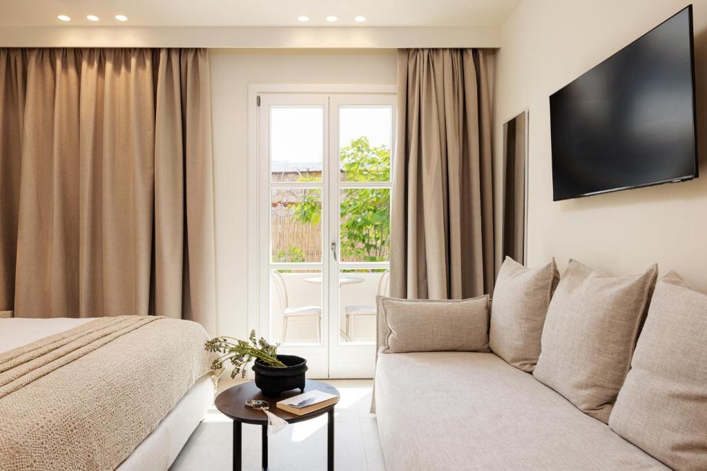 une chambre d'hôtel avec un canapé et une fenêtre dans l'établissement Doryssa Method Hotel, à Pythagoreio