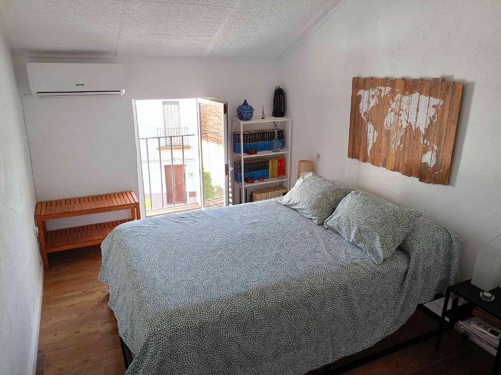 um quarto com uma cama e uma estante de livros em Casa Rural El Palomar em El Pedroso