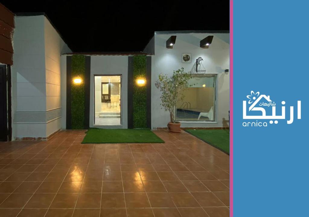 un pasillo de una casa con una puerta y una planta en شالية ارنيكا en As Sayl aş Şaghīr