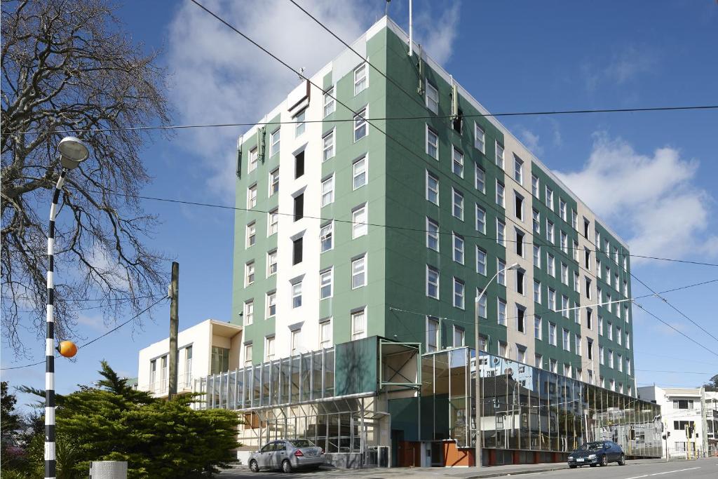 un edificio verde y blanco en una calle de la ciudad en Willis Wellington Hotel, en Wellington