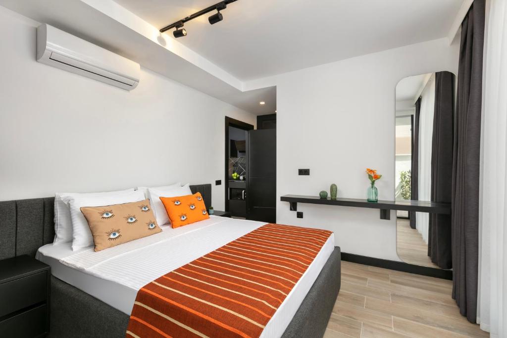 ein Schlafzimmer mit einem großen Bett mit orangefarbenen Kissen in der Unterkunft Ella Suites Hotel in Antalya