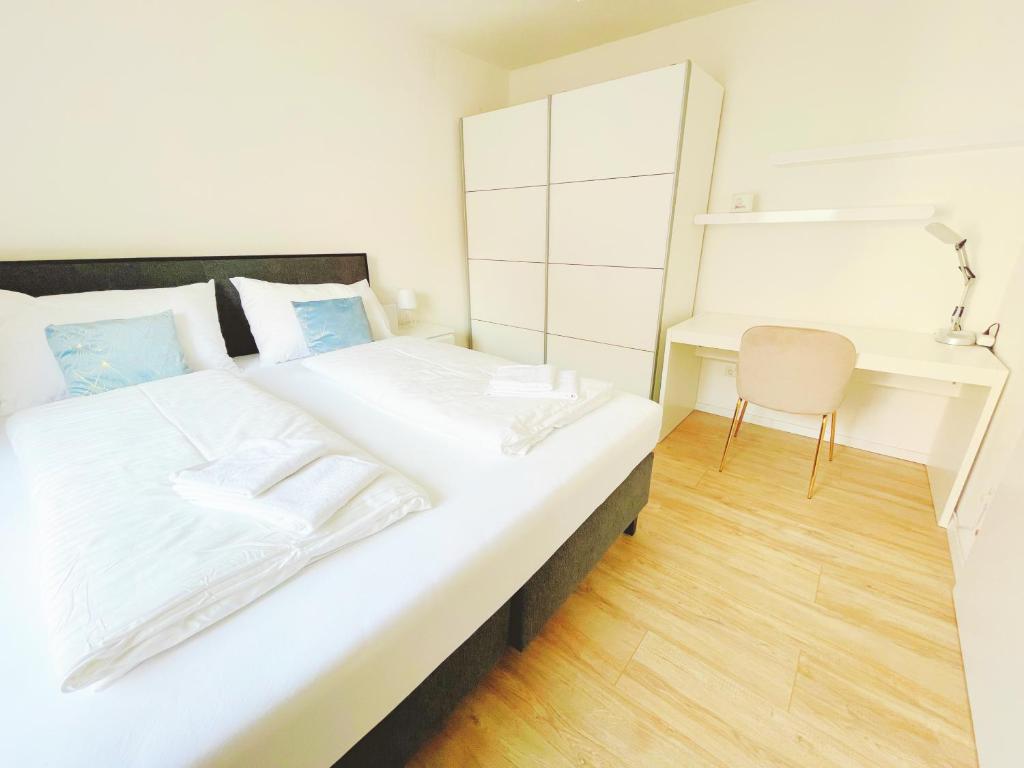 een slaapkamer met een groot wit bed en een bureau bij StayHere Central City Suite 11 - contactless Self-Check-IN in Graz