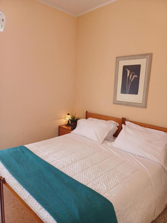 - une chambre avec un lit blanc et une couverture bleue dans l'établissement Alloggio Taddei, à Barisciano