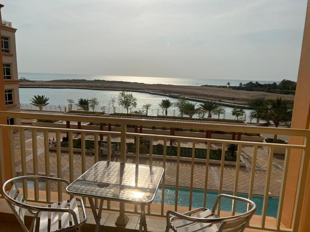 a table and chairs on a balcony with a view of the ocean at شقه ليالي المارينا اطلاله بحريه عوائل in King Abdullah Economic City