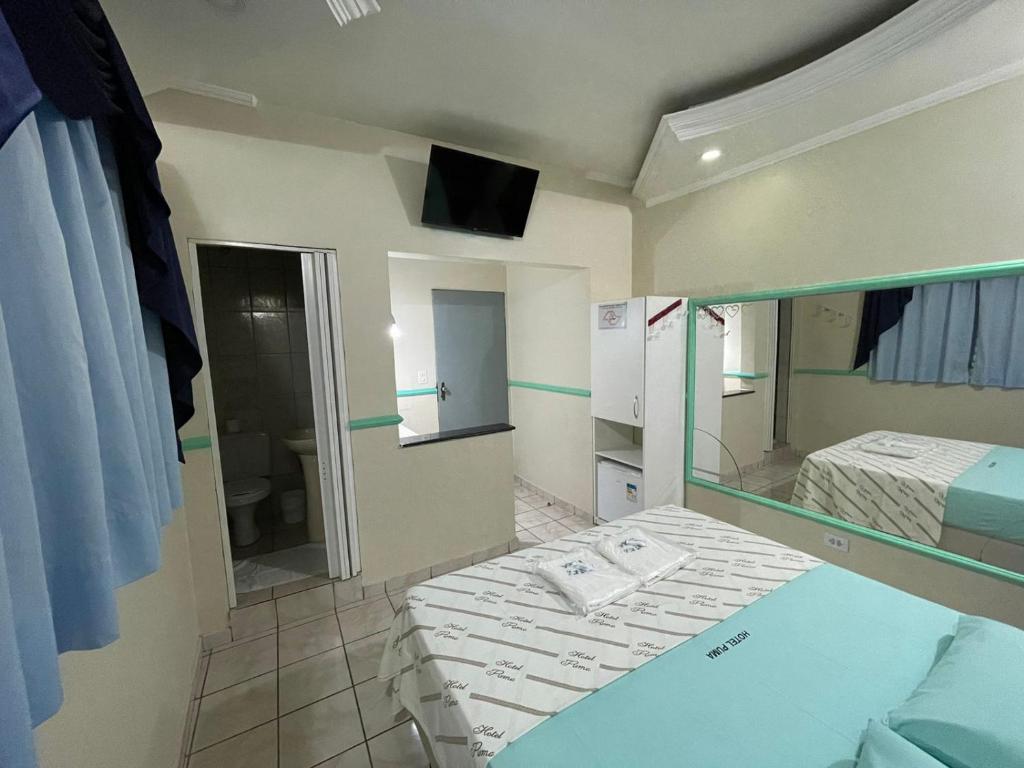 ein kleines Zimmer mit einem Bett und einem Spiegel in der Unterkunft Hotel Puma in São Paulo