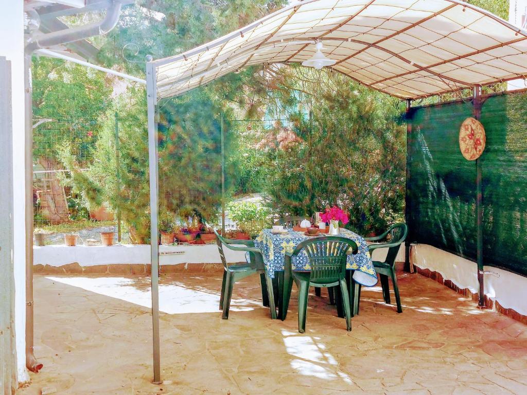 een patio met een tafel en stoelen onder een tent bij casa panoramica in Teulada