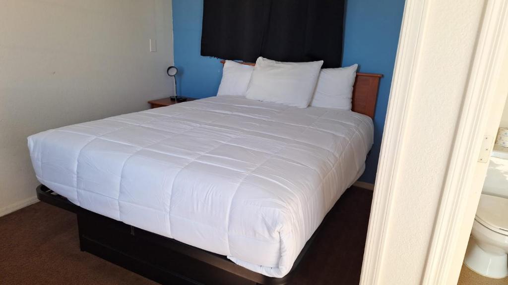 uma cama com lençóis brancos e almofadas num quarto em 075B Affordable Retreat nr South Rim Sleeps 2 em Valle