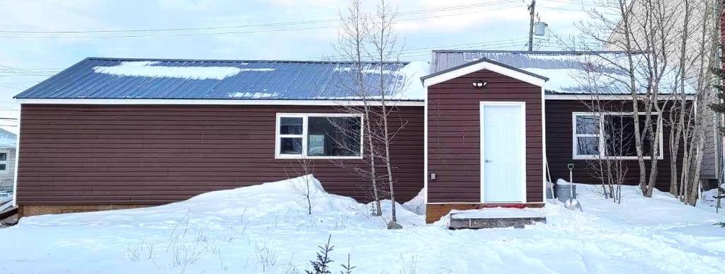 una pequeña casa con nieve delante en Caribou Cottage, en Churchill