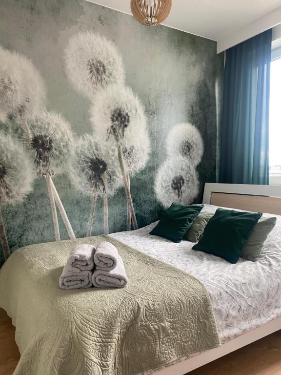 1 dormitorio con 1 cama con dientes de león en la pared en Airport Green Apartment KL21 - free parking, en Varsovia