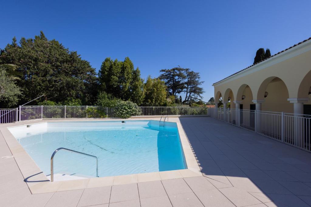 - une piscine sur une terrasse à côté d'un bâtiment dans l'établissement Adorable 2P avec Piscine Cannes, à Cannes