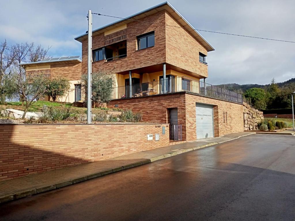 a brick house on the side of a street at el turó in Sant Boi de Lluçanès