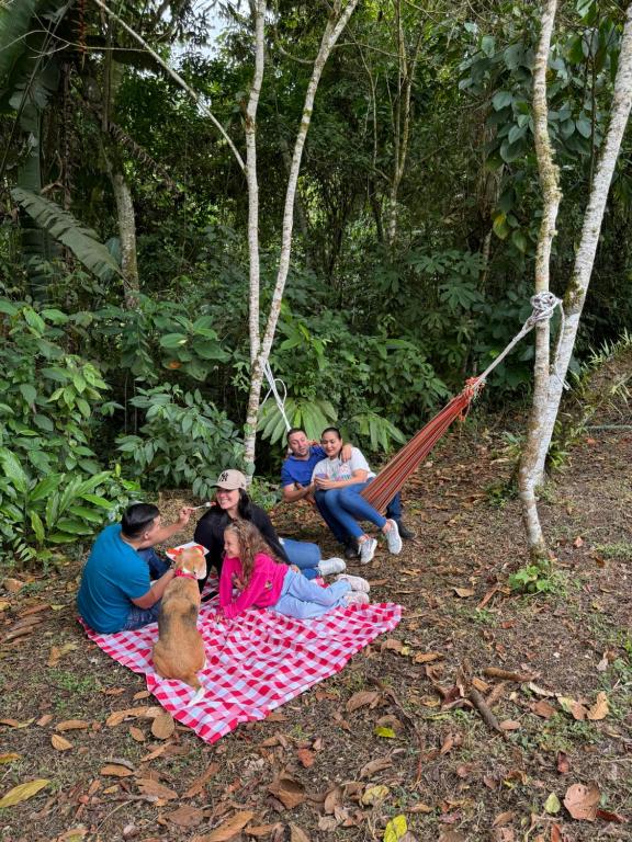 eine Gruppe von Menschen, die auf einer Picknickdecke sitzen in der Unterkunft Eco hotel Birdland en Buga Valle in La Habana