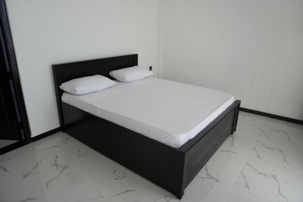 1 cama con 2 almohadas en una habitación en SHAKIN SHASHA BEACH HOUSE en Jaffna