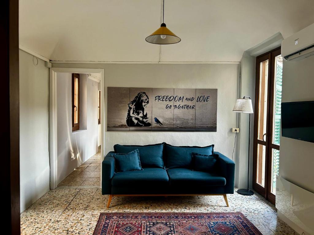 a living room with a blue couch and a painting at Casa Feliciani - MonferratoHome in Viarigi