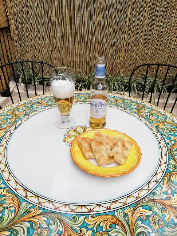 a table with a bottle of beer and a plate of food at Apartment/Studio il Girasole in Rapallo