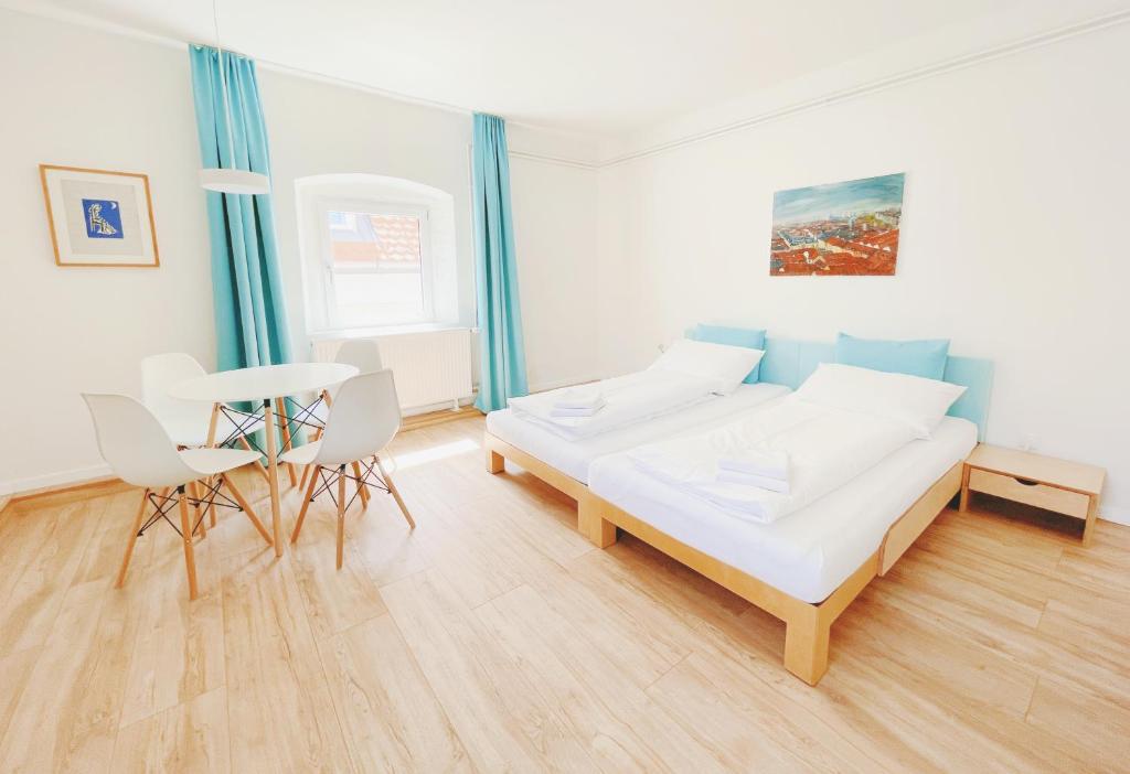 a bedroom with a bed and a table and chairs at StayHere Central City Studio 13 - contactless Self-Check-IN in Graz