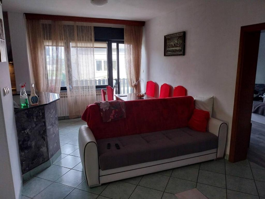 uma sala de estar com um sofá e cadeiras vermelhas em Dijana Gloria em Zadvorsko