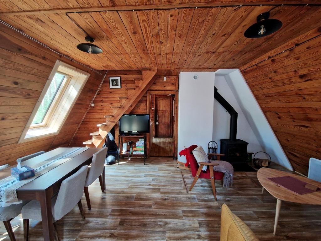 a living room with wooden ceilings and wooden floors at Leśna Chatka in Wola Polska
